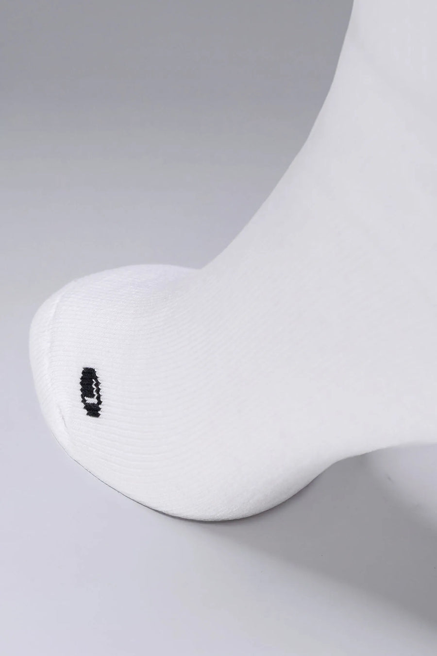 Detailed Toe View of White the TLF Evolve Crew Socks featuring an extended cuff height, ribbed cuff, cushioned footbed and seamless toe