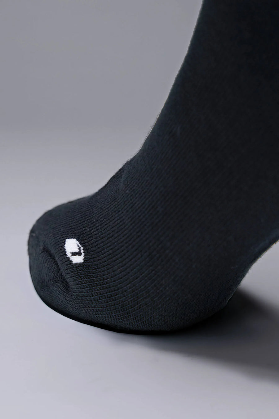Detail Toe View of Black the TLF Evolve Half Crew Socks featuring an extended cuff height, ribbed cuff, cushioned footbed and seamless toe
