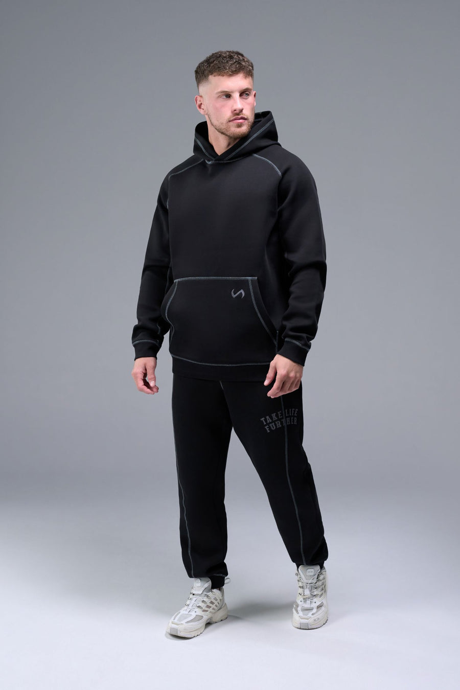 Side View of Black TLF Scuba Tech Contrast Stitch Joggers, featuring side zipper pockets and contrast stitching for streetwear aesthetic