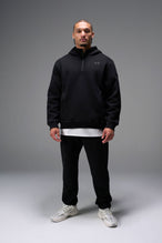 Side View of Black TLF GTS Twill Tech Quarter-Zip Hoodie worn with matching black joggers, featuring contrast stitching and kangaroo pockets