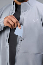 Detail Front View of Gray TLF Element Athletic Jacket, featuring multiple zipper pockets, and ripstop panels for breathability and stretch 