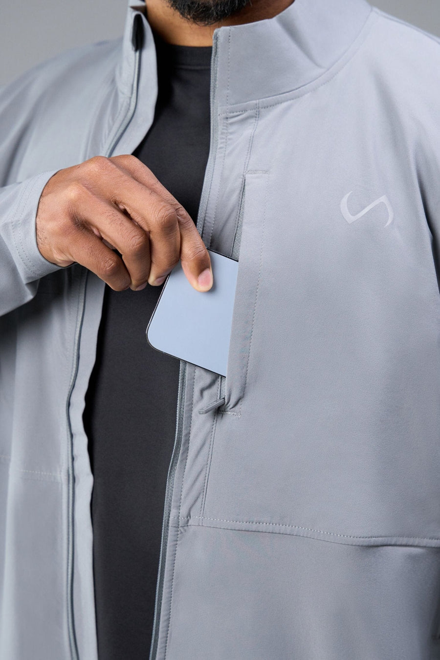 Detail Front View of Gray TLF Element Athletic Jacket, featuring multiple zipper pockets, and ripstop panels for breathability and stretch 