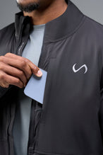 Detail Front View of Black TLF Element Athletic Jacket, featuring multiple zipper pockets, and ripstop panels for breathability and stretch 