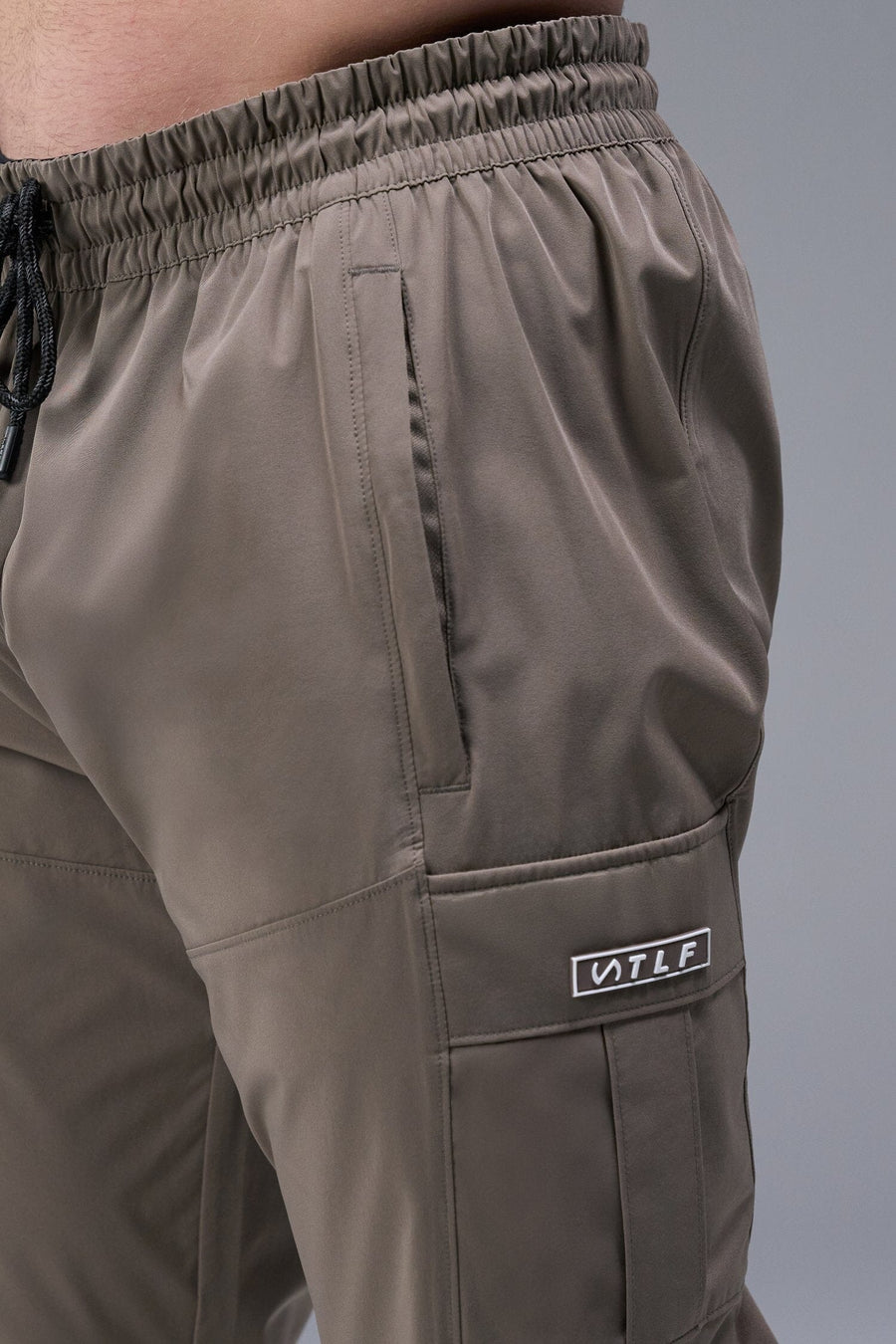 Detail Front View of Brown TLF Element Athletic Joggers 2.0, featuring side zipper pockets and side leg cargo pockets and reflective details 
