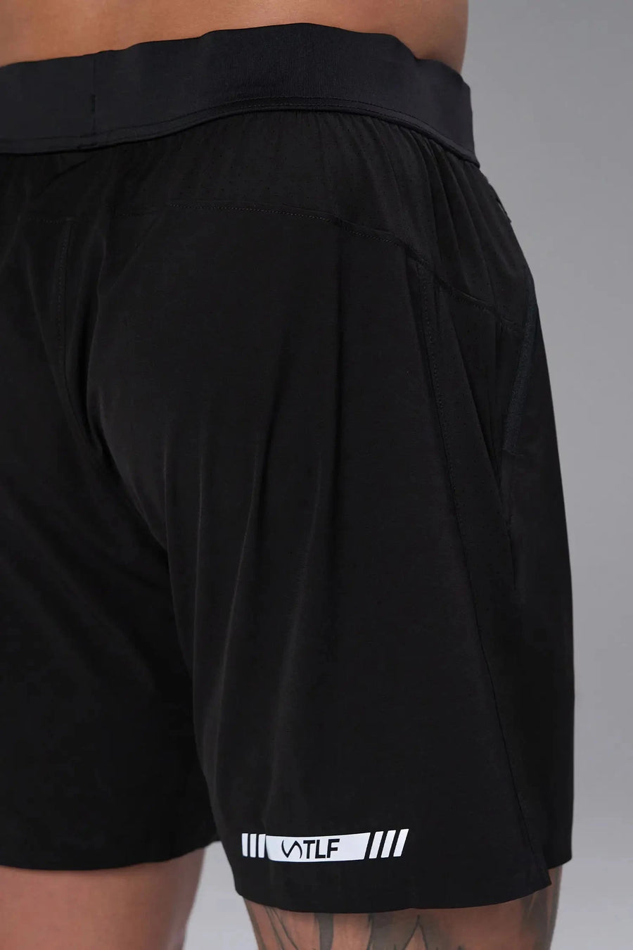 Back View of the Black the TLF Element Light 7 Inch Shorts featuring side zipper pockets, side split hems and reflective details for nighttime visibility