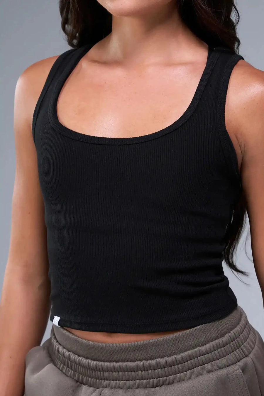 Front View of Black TLF Essential Ribbed Tank Top, featuring a scoop neckline in our ribbed tech fabric 