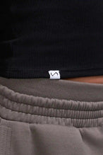 Detail Logo View of Black TLF Essential Ribbed Tank Top, featuring a scoop neckline in our ribbed tech fabric 