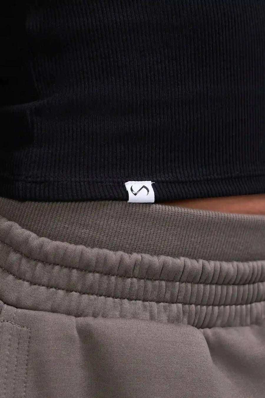 Detail Logo View of Black TLF Essential Ribbed Tank Top, featuring a scoop neckline in our ribbed tech fabric 
