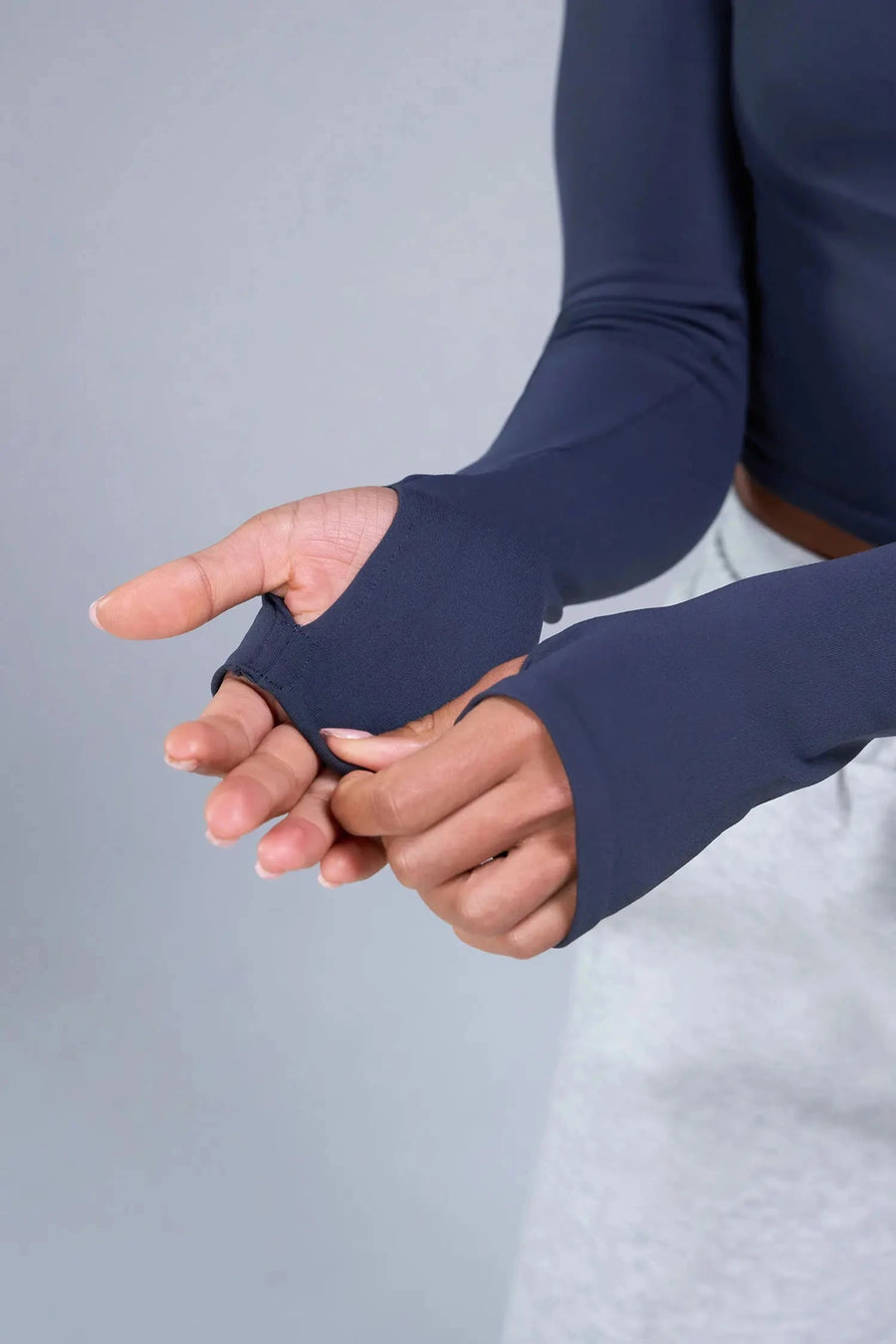 Detail Sleeves View of Blue TLF Essential Seamless off the shoulder top, featuring a cropped length and thumbholes 