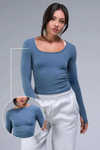 Front View of Blue TLF Essential Seamless Reversible Scoop Neck, featuring thumbholes and multi wear for boat neck or scoop neck styling 