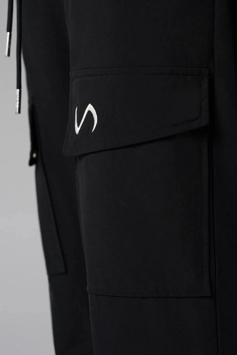 Detail View of Black the TLF GTS Element-Max Cargo Pants featuring front cargo pockets and an adjustable ankle drawcord ankle for custom fit
