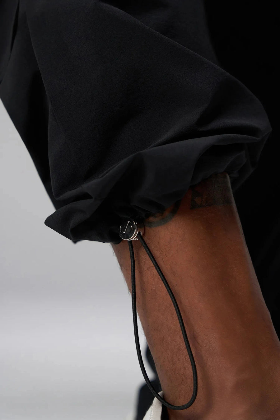 Detail View of Black the TLF GTS Element-Max Cargo Pants featuring front cargo pockets and an adjustable ankle drawcord ankle for custom fit