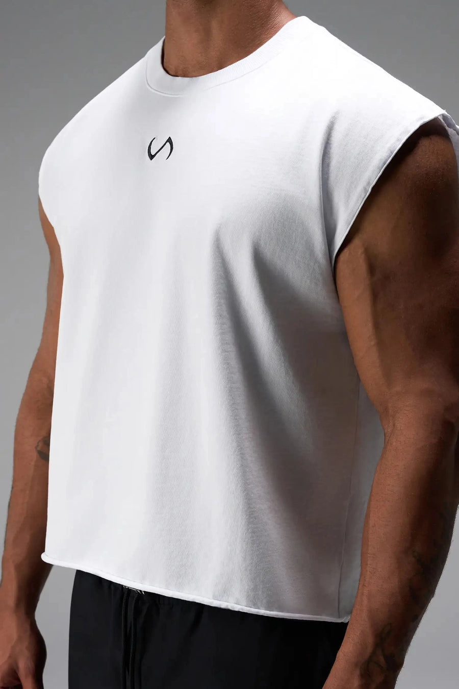 Side View of White the TLF Icon Muscle Tank featuring our physique enhancing design, straight hem and relaxed fit. 