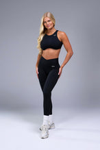 Front View of Black TLF Tempo Side Pocket Leggings, featuring dual side pockets and crossover waistband for performance and functionality 