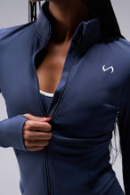 Detail Front View of Blue TLF Tempo Cropped Zip Up Jacket featuring thumbholes and cropped length for gym and lifestyle wear 