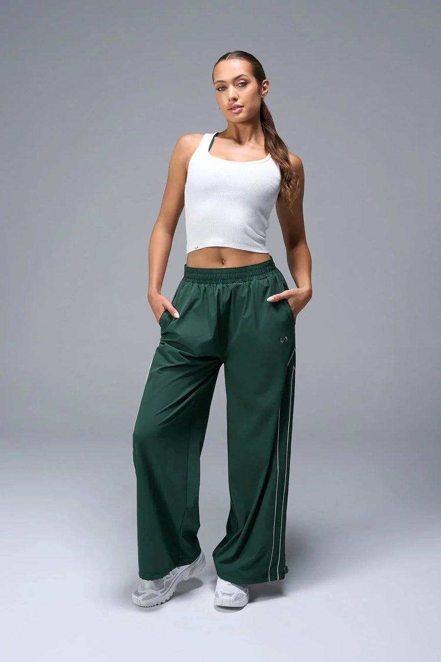 Front View of Green TLF Baggy Track Pants (Women’s GTS Gym-To-Street Edition) featuring side pockets and reflective piping details.