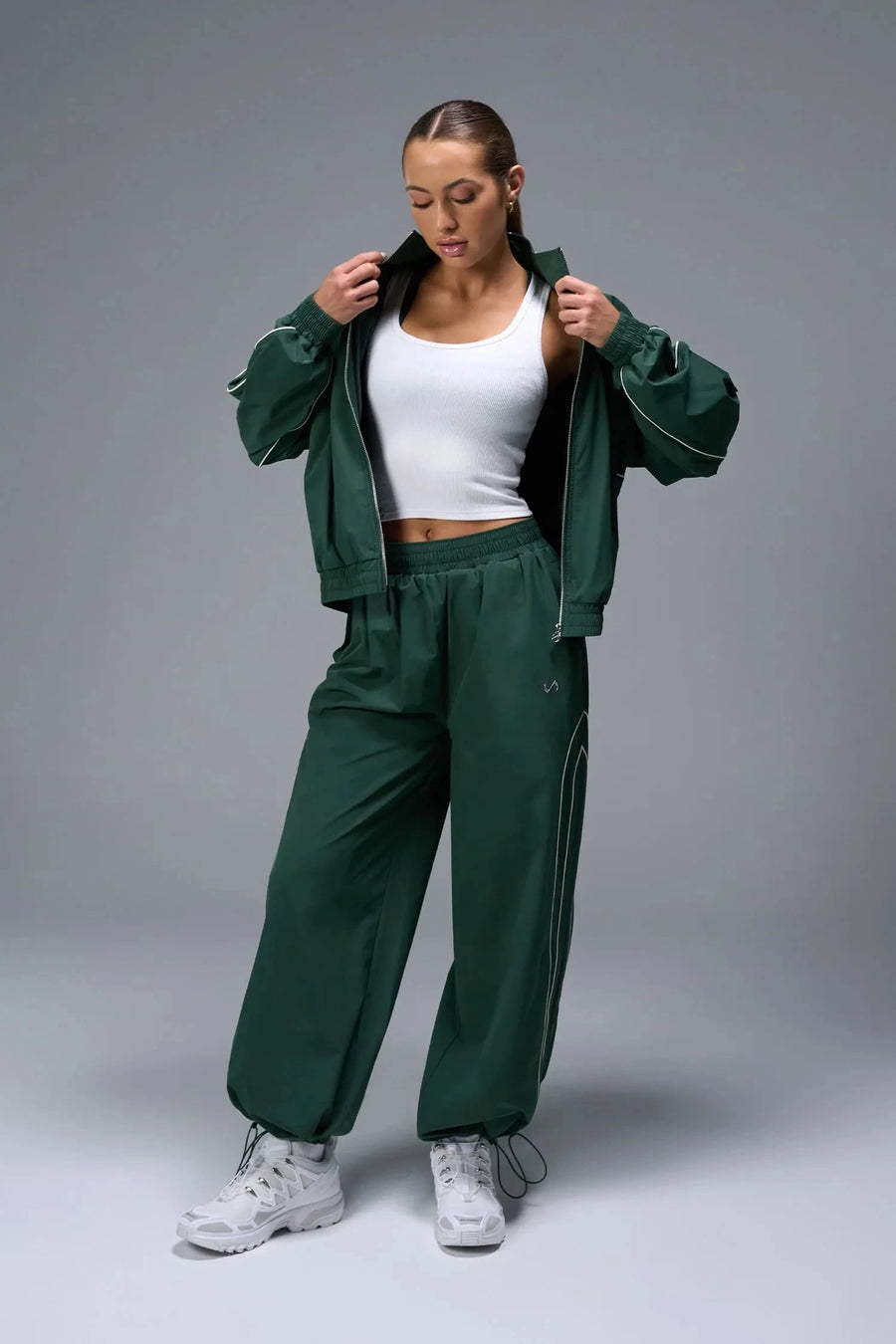 Front View of Green TLF Baggy Track Pants (Women’s GTS Gym-To-Street Edition) featuring side pockets and reflective piping details.