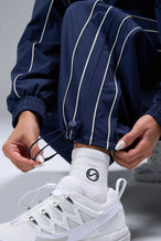 Detail View of Blue TLF Baggy Track Pants (Women’s GTS Gym-To-Street Edition) featuring side pockets and reflective piping details.
