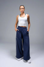 Back View of Blue TLF Baggy Track Pants (Women’s GTS Gym-To-Street Edition) featuring side pockets and reflective piping details.