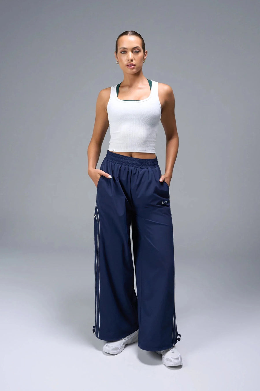 Back View of Blue TLF Baggy Track Pants (Women’s GTS Gym-To-Street Edition) featuring side pockets and reflective piping details.